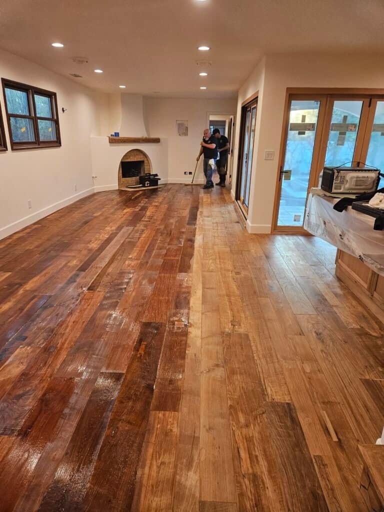 Handcrafted hardwood flooring installation in living room with natural wood finish.