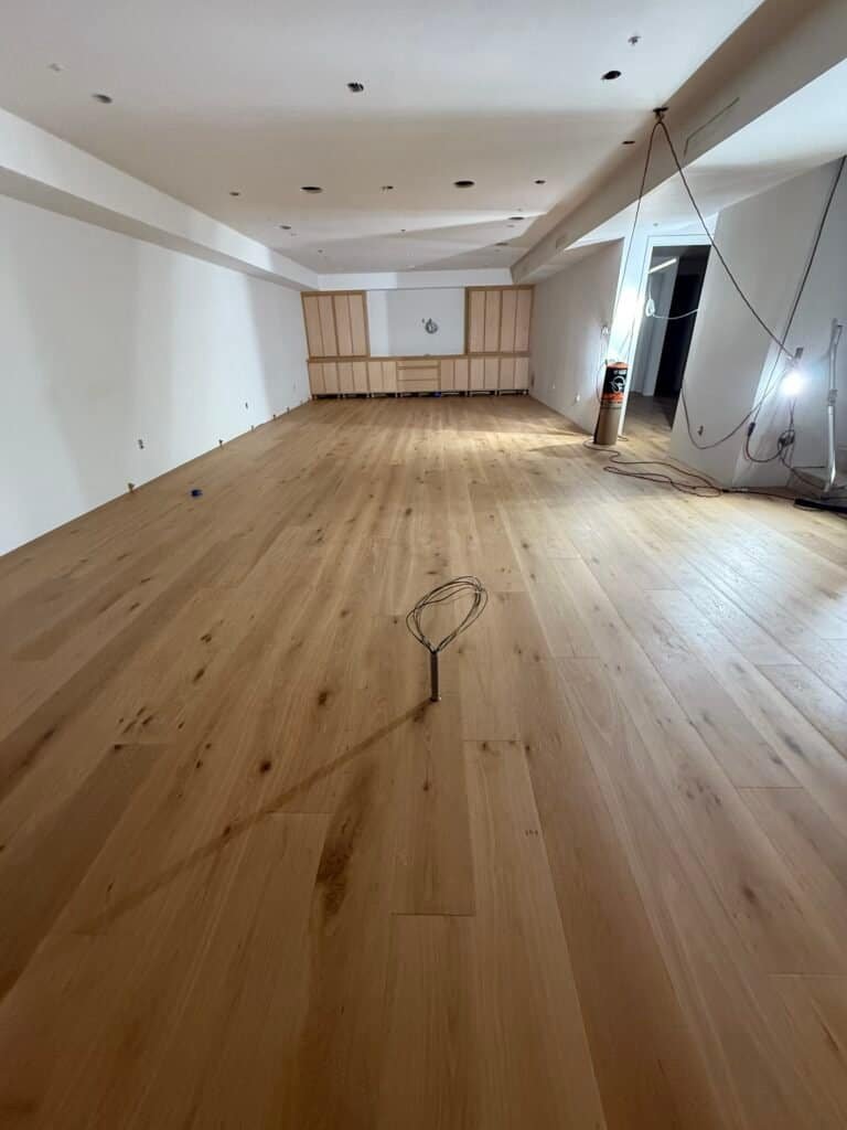 Smooth hardwood flooring installation in spacious living room by GTO Hardwood Floors. Perfect for modern home interior renovation.