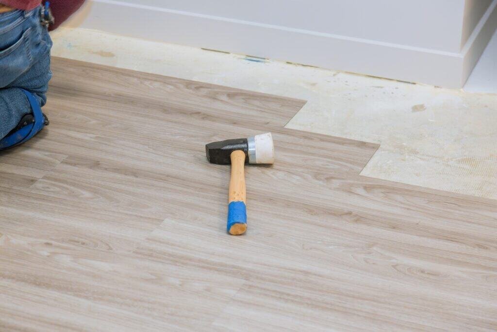 Hammer on a hardwood floor during flooring installation or refinishing.